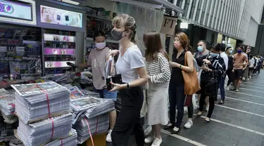 Orang-orang mengantre untuk edisi terakhir Apple Daily di stan surat kabar di sebuah jalan pusat kota di Hong Kong, Kamis (24/6/2021). Ratusan orang mengantre pada Kamis dini hari untuk membeli edisi cetak terakhir surat kabar pro-demokrasi Hong Kong, Apple Daily. ( AP Photo/Vincent Yu)