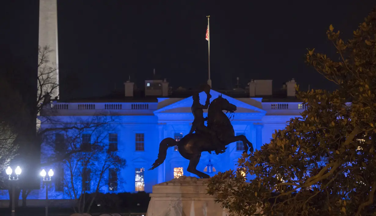Cahaya warna biru menerangi Gedung Putih untuk menandai Hari Kesadaran Autisme Sedunia atau World Autism Awareness Day, di Washington, DC, Minggu (2/4). Tanggal 2 April adalah Hari Kesadaran Autisme Sedunia. (SAUL LOEB / AFP)