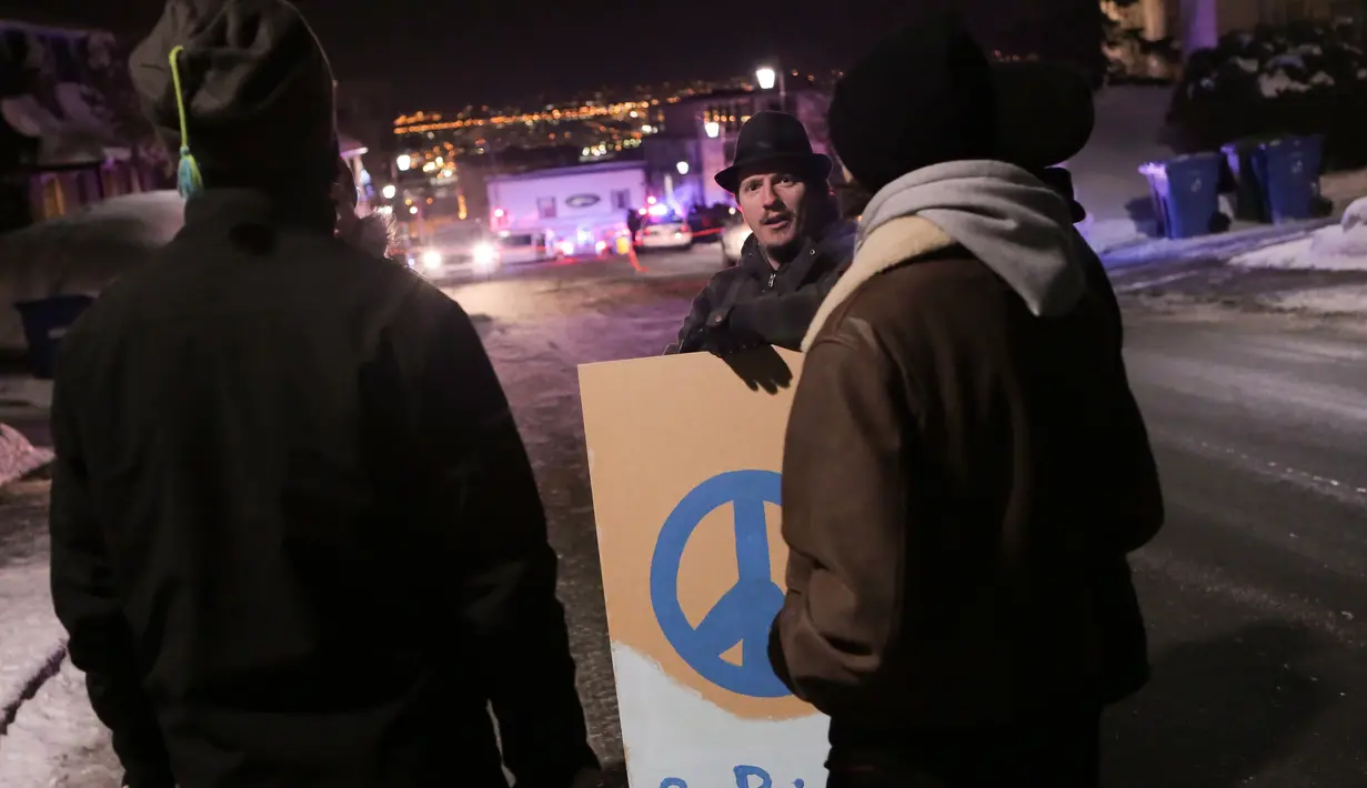 Warga berada di dekat sebuah masjid usai penembakan di Quebec City, Kanada (29/1). Sekitar tiga orang bersenjata menembaki sekitar 40 orang di dalam Pusat Kebudayaan Islam Quebec City. (The Canadian Press/Francis Vachon)