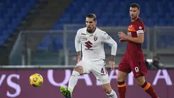 Bek Torino Lyanco Vojnovic mengoper bola dari kawalan penyerang Roma Edin Dzeko pada pertandingan Liga Serie A Italia di stadion Olimpiade, Jumat (18/12/2020). Berkat kemenangan itu, Roma kini melejit ke posisi ke-4 klasemen sementara Liga Italia. (AFP Photo/Vincenzo Pinto)