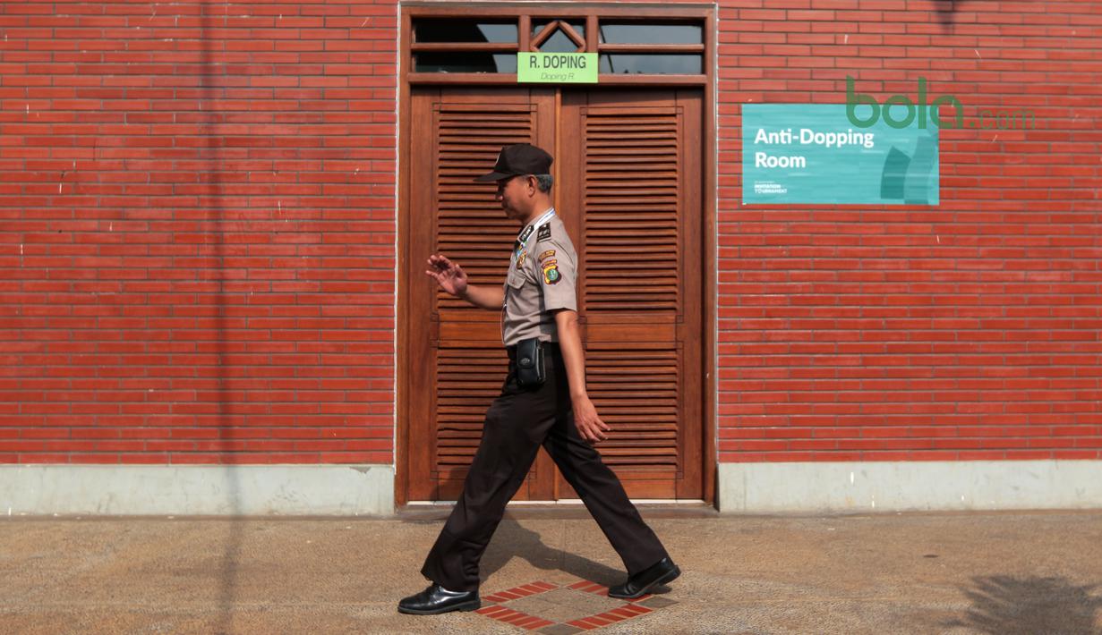 Polisi melintas dekat ruang tes anti dopping pada Test Event Asian Games 2018 di Padepokan Silat TMII, Jakarta, Senin (12/2/2018). Sebanyak sepuluh negara mengikuti test event pencak silat 2018 tersebut. (Bola.com/Nick Hanoatubun)