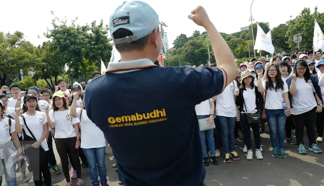 Massa yang tergabung dalam Generasi Muda Buddhis Indonesia (Gemabudhi) melakukan persiapan sebelum membagikan bunga kepada pengguna jalan di depan Istana Negara, Jakarta, Sabtu (6/1). (Liputan6.com/Immanuel Antonius)