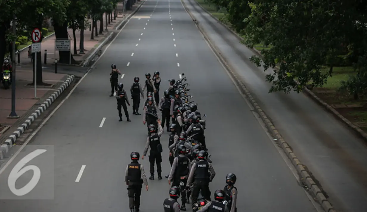 Aparat mengamankan aksi longmarch kisruh freeport menuju Istana Negara, Jakarta, Rabu (16/12). Dalam aksinya meminta DPR jangan melanggar UU bahwa Sidang MKD harus tertutuo sesuai dengan UU. (Liputan6.com/Faizal Fanani)