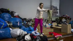 Relawan Ukraina menyortir pakaian yang disumbangkan untuk kemudian didistribusikan ke penduduk setempat di Lviv, Ukraina barat, pada Rabu (2/3/2022). Invasi Rusia ke Ukraina telah memasuki hari keenam. (AP Photo/Bernat Armangue)