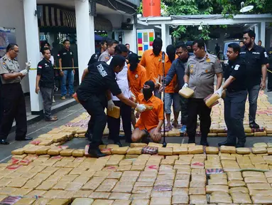 Petugas menunjukkan tersangka dan barang bukti narkoba jenis ganja saat rilis di Polda Metro, Jakarta, Senin (30/7). Sebanyak 1.434 kg ganja jaringan Aceh-Jakarta-Bogor diamankan petugas berikut 6 orang tersangka. (Merdeka.com/Arie Basuki)