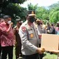 Seorang warga lansia menerima paket sembako gratis saat mengikuti vaksinasi yang digelar oleh Polda Sulut.