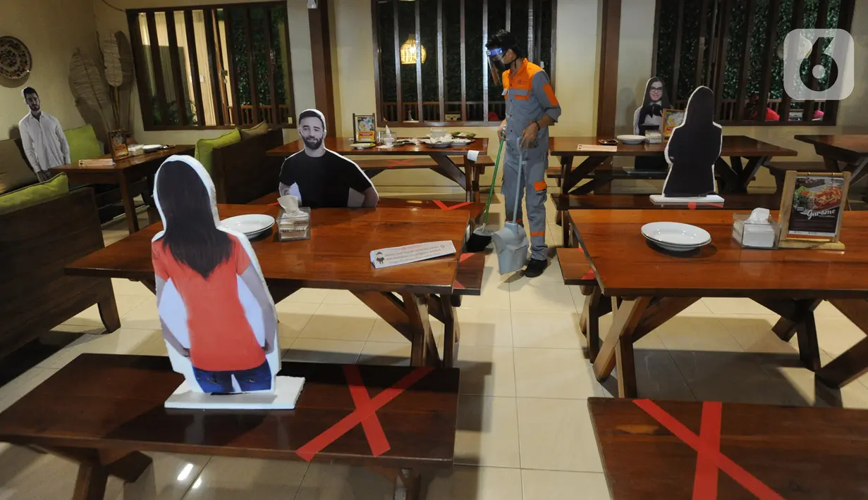 Petugas kebersihan menggunakan pelindung wajah dan masker di Rumah Makan Bumi Aki, Pajajaran, Kota Bogor, Minggu  (31/5/2020). Sejumlah restoran dan rumah makan di Bogor mulai membuka layanan makan di tempat dengan protokol kesehatan ketat guna mengatasi pandemi COVID-19. (merdeka.com/Arie Basuki)