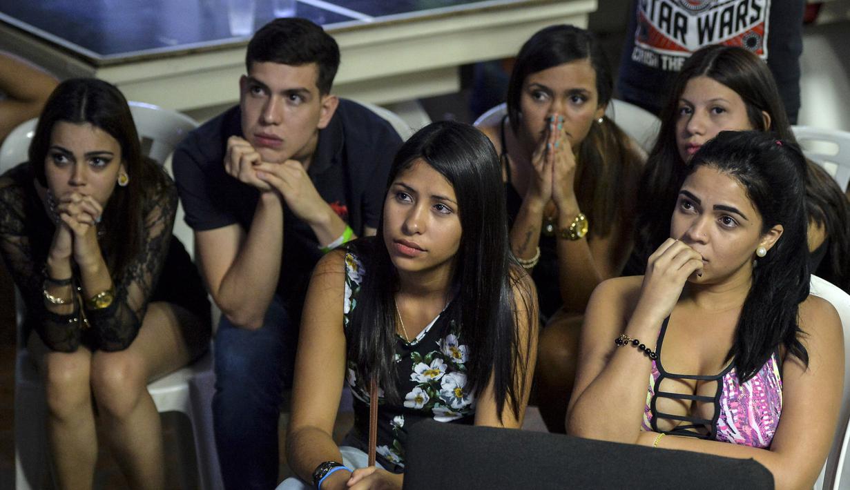 Fans cantik Venezuela dengan wajah tegang dan cemas menonton timnya bertanding pada final Piala Dunia U-20 lewat layar TV di Caracas, Venezuela, (11/6/2017). (AFP/Luis Robayo)