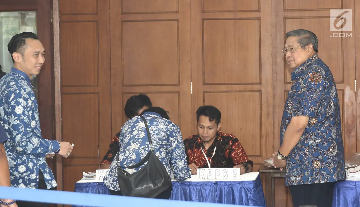 Presiden ke-6 RI, Susilo Bambang Yudhoyono dan putra bungsunya, Edhie Baskoro Yudhoyono atau Ibas menggunakan hak politiknya pada Pilkada Serentak 2018 di TPS 06 Nagrak, Gunung Putri, Bogor, Rabu (27/6). (Liputan6.com/Herman Zakharia)
