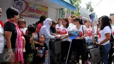 Relawan dari Gerakan Aksi Srikandi Coblos Ahok (Gadis Ahok) memberikan sapu dan tempat sampah ke warga di kawasan Cipete, Jakarta Selatan, Senin (26/12). Sebanyak 150an kantong sampah dan sapu dibagikan ke warga. (Liputan6.com/Gempur M Surya)