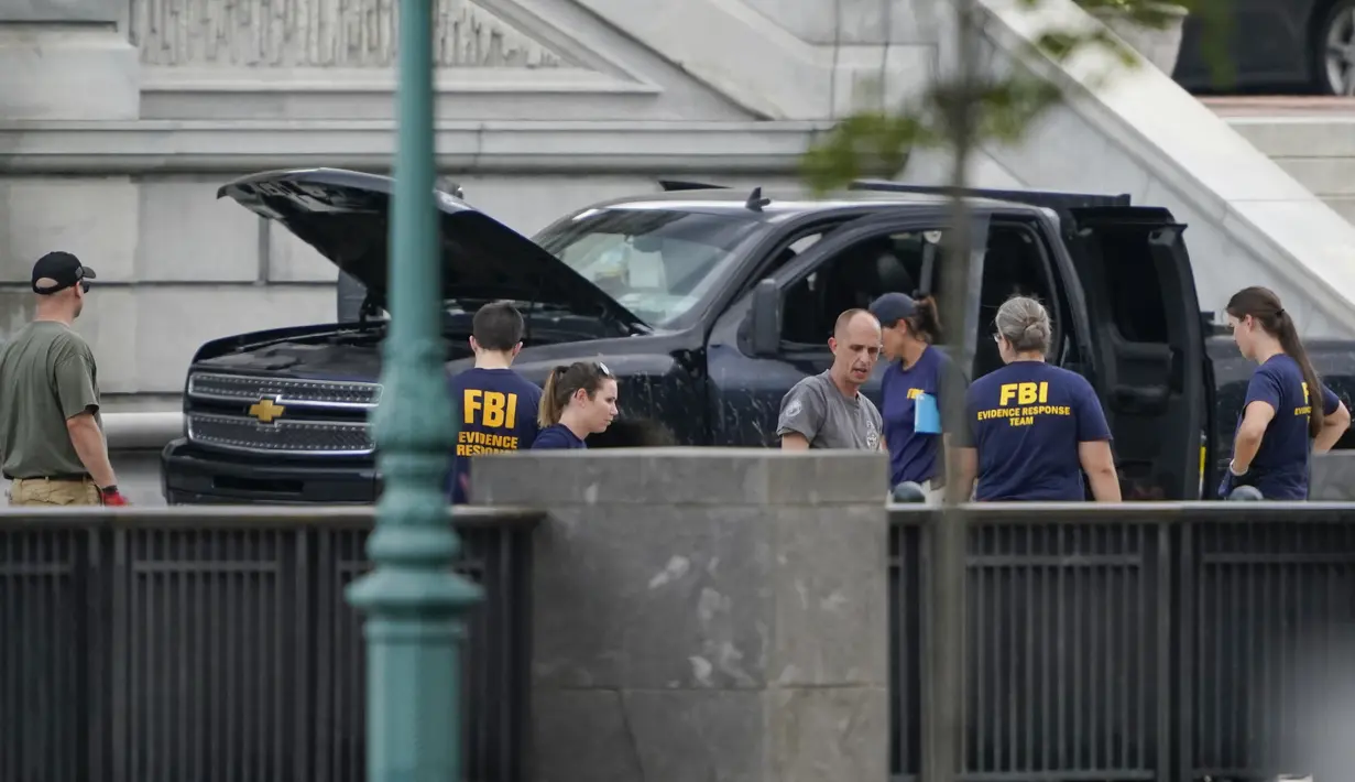 Pihak berwenang menyelidiki sebuah truk pikap yang diparkir di trotoar di depan Perpustakaan Kongres AS, sebelah timur gedung Capitol, Washington, Kamis (19/8/2021). Pria di truk pikap yang mengancam akan meledakkan bom di dekat gedung Capitol AS itu telah menyerahkan diri (AP Photo/Carolyn Kaster)