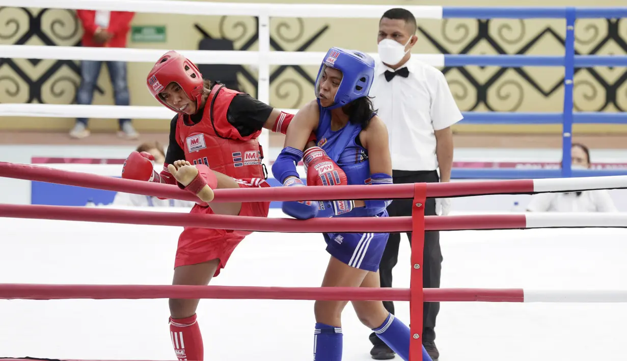 Atlet Muaythai NTT, Susanti Ndapataka (merah) bertarung dengan atlet Muaythai Papua, Iriani Labagai (biru) saat babak penyisihan Muaythai kelas 70 kg putri di GOR STT Gidi, Sentani, Papua, Rabu (29/9/2021). (FOTO : PBPON XX PAPUA/Dhoni Setiawan)