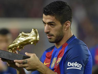 Striker Barcelona, Luis Suarez, menunjukan Sepatu Emas jelang laga La Liga melawan Granada di Stadion Nou Camp, Spanyol, Sabtu (29/10/2016). Suarez meraih gelar ini usai mencetak 40 gol pada musim lalu. (AFP/Lluis Gene)