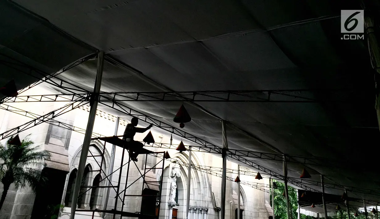 Pekerja memasang dekorasi Natal di tenda Gereja Katedral, Jakarta, Selasa (19/12). Persiapan seperti perawatan interior-eksterior gereja serta pemasangan dekorasi mulai dilakukan pihak gereja untuk menyambut Hari Natal. (Liputan6.com/Immanuel Antonius)