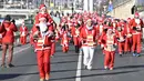 Orang-orang dengan kostum Sinterklas ikut serta dalam lomba lari tradisional menyambut Natal di tepi Sungai Danube di Budapest, Hungaria, pada tanggal 3 Desember 2023. (ATTILA KISBENEDEK/AFP)