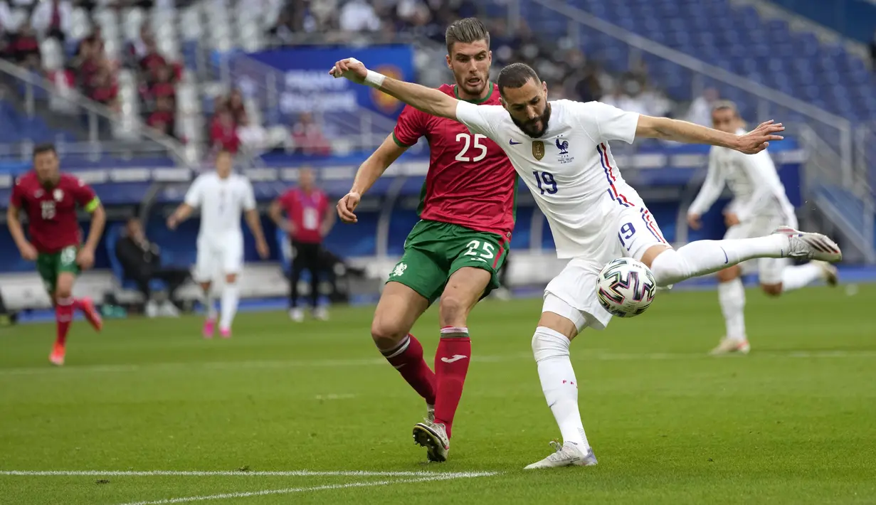 Pemain depan timnas Prancis, Karim Benzema berebut bola dengan bek Bulgaria, Petko Hristov pada laga uji coba menjelang Piala Eropa 2020 di Stade de France, Rabu (9/6/2021) dini hari WIB. Timnas Prancis menaklukkan Bulgaria dengan skor meyakinkan 3-0. (AP Photo/Francois Mori)