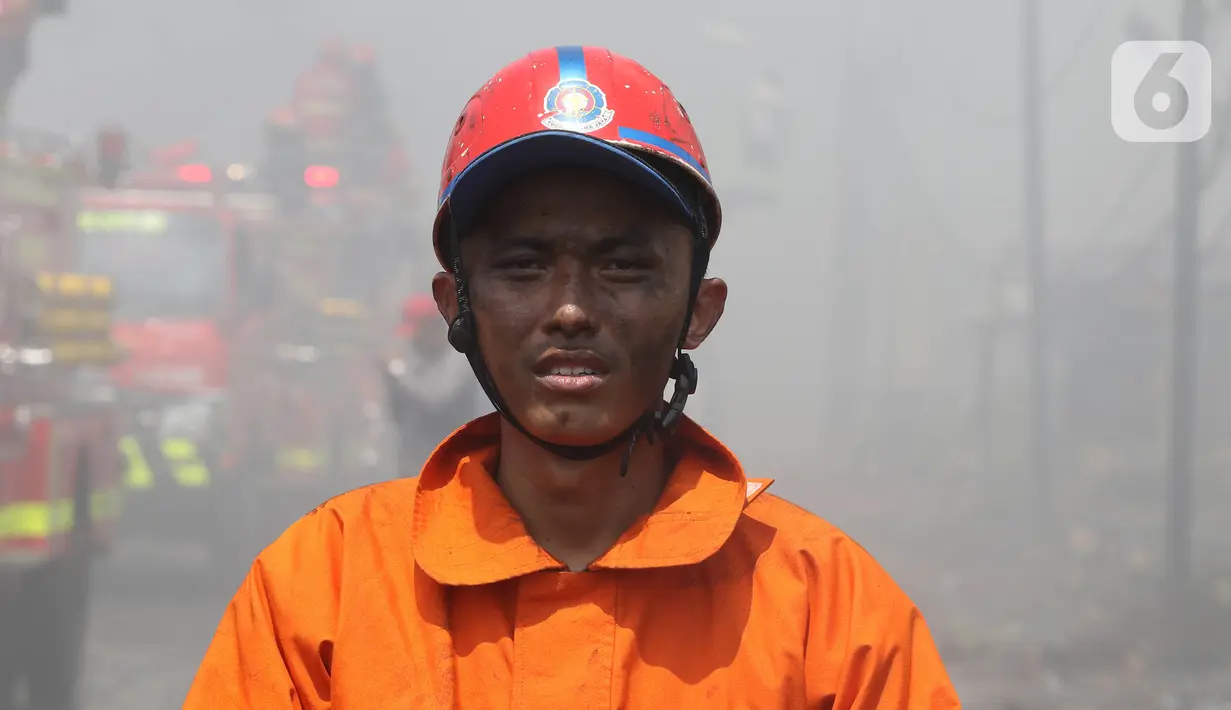 Ekspresi petugas pemadam kebakaran seusai memadamkan api di lapak ban bekas, Desa Bojong Nangka, Gunung Putri, Bogor, Kamis (22/4/2021). Kebakaran lapak ban bekas yang terjadi Senin (19/4) petang tersebut hingga saat ini belum bisa dipadamkan. (Liputan6.com/Herman Zakharia)