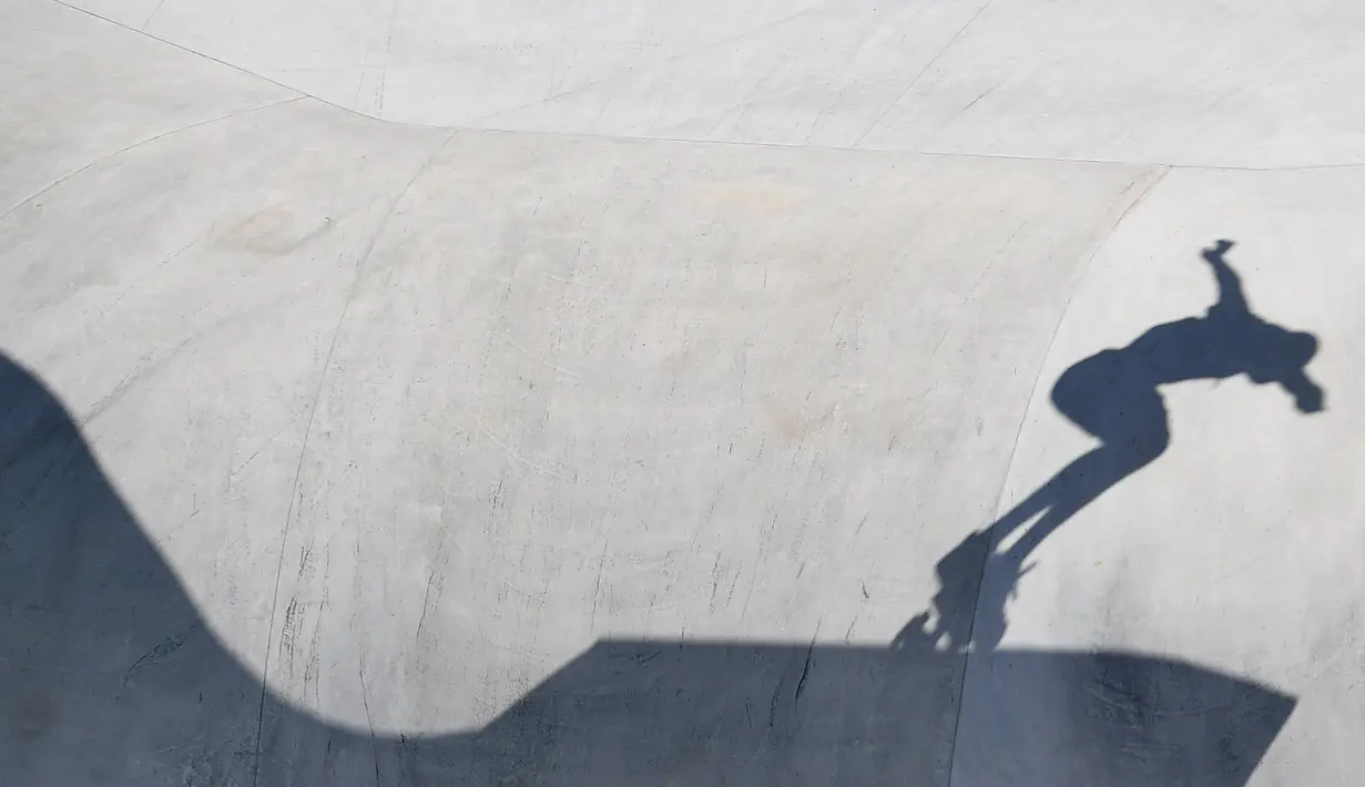 Siluet atlet Skateboard pria saat berkompetisi selama Olimpiade Tokyo 2020 di Ariake Sports Park Skateboarding di Tokyo, Jepang, Kamis (5/8/2021). (AFP/Loic Venance)