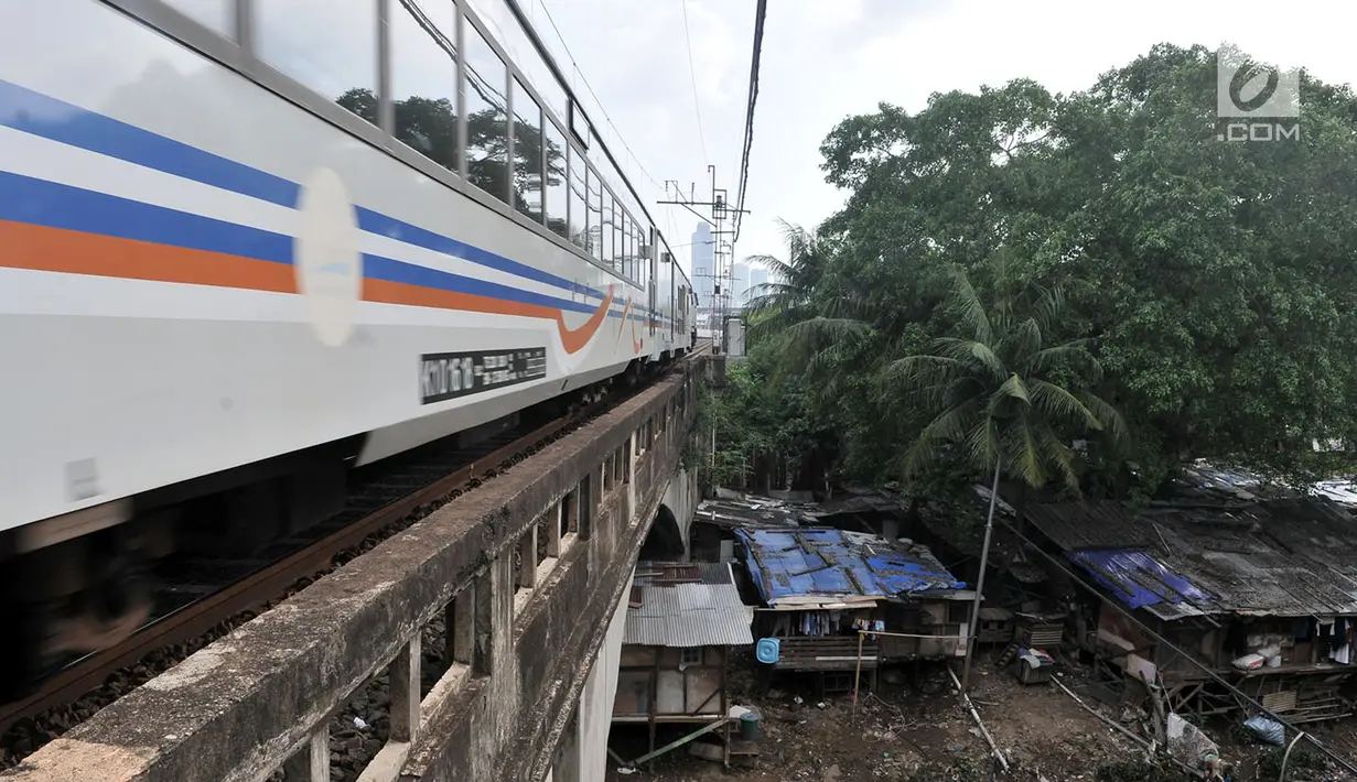 Kereta api melintas di atas bangunan liar yang berada di bantaran Kali Ciliwung, Jakarta, Kamis (12/4). Warga sekitar mengaku betah tinggal di bantaran kali meski rela kebanjiran di kala musim penghujan. (Merdeka.com/Iqbal Nugroho)
