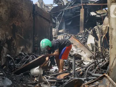 Warga mengais puing sisa kebakaran toko dan pemukiman di kawasan Manggarai, Jakarta, Selasa (7/7/2020). Tidak ada korban jiwa dalam peristiwa itu, namun akibat kebakaran sebanyak 40 bangunan yang didominasi toko mebel ludes terbakar. (Liputan6.com/Immanuel Antonius)