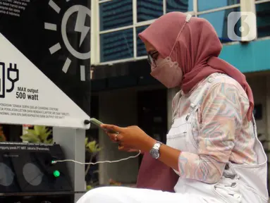 Seorang perempuan mengisi ulang daya ponsel pada stasiun Pengisian Listrik Bertenaga Surya atau Solar Charging Station di kawasan Transit Oriented Development (TOD) I Dukuh Atas, Jakarta, Rabu (10/11/2022). PT Mass Rapid Transit (MRT) Jakarta menyediakan tiga Solar Charging Station yang tersebar di area TOD I Dukuh Atas. (Liputan6.com/Johan Tallo)