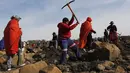 Seorang wanita menggunakan kapak saat mencari batu yang diyakini berlian di Desa KwaHlathi, luar Ladysmith, Provinsi KwaZulu-Natal, Afrika Selatan (15/6/2021). Kehebohan yang disebut-sebut sebagai 'demam berlian' ini bermula setelah penemuan batu misterius di kawasan tersebut. (AFP/Phill Magakoe)