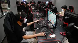 Sejumlah orang bermain game komputer di sebuah kafe internet di Beijing, China, Jumat (10/9/2021). China kini membatasi waktu bermain game online bagi anak-anak dan remaja yang mulai berlaku minggu ini. (GREG BAKER/AFP)