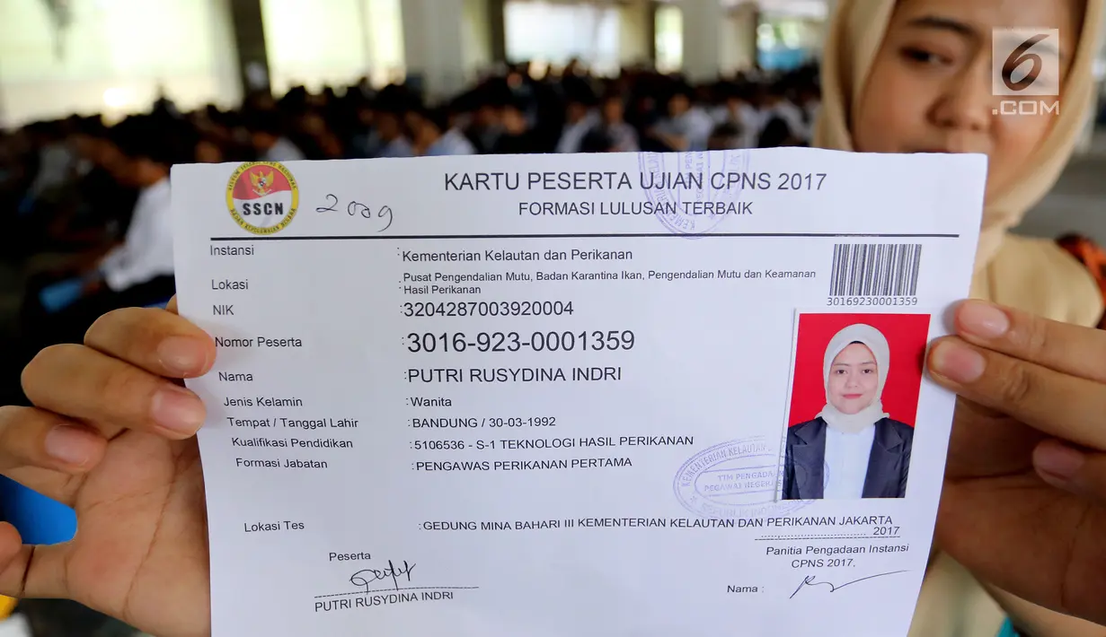 Peserta menunjukkan kartu ujian CPNS Kementerian Kelautan dan Perikanan (KKP) di Jakarta, Minggu (8/10). Pembukaan lowongan CPNS ini dalam rangka mengisi kekosongan 41 jabatan pada Kantor Pusat dan UPT di KKP. (Liputan6.com/Johan Tallo)