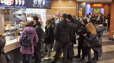 Orang-orang berbaris di restoran McDonald's pada hari kerja terakhirnya di St. Petersburg, Rusia, Senin (14/3/2022). Gerai makanan cepat saji McDonald’s memutuskan setop beroperasi dari Rusia pasca invasi yang dilakukan Negeri Beruang Merah terhadap Ukraina. (AP Photo)