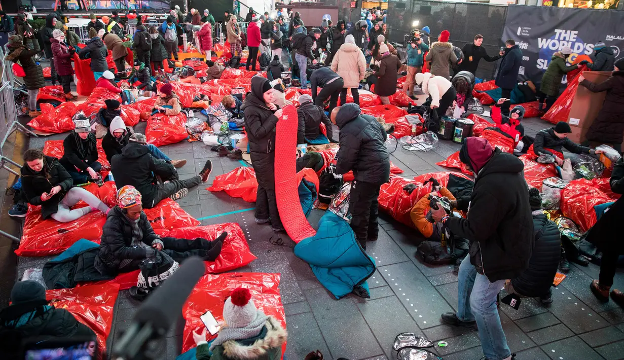 Orang-orang menyiapkan kantong tidur di area terbuka selama acara World's Big Sleep Out di New York, 7 Desember 2019. Aksi yang dilakukan di beberapa kota besar dunia ini sebagai bagian dari upaya penggalangan dana untuk membantu para tunawisma di banyak negara. (AP/Julius Constantine Motal)