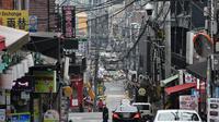 Seorang pria yang mengenakan masker berjalan di distrik kehidupan malam populer Itaewon di Seoul pada 10 Mei 2020. (JUNG YEON-JE / AFP)