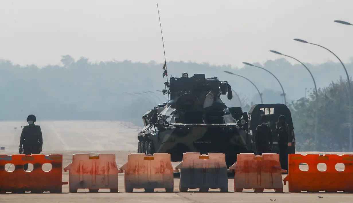 Tentara Myanmar berjaga di penghalang jalan yang diawaki dengan kendaraan lapis baja di jalan menuju gedung parlemen di Naypyitaw, Myanmar, Selasa (2/2/2021). Militer Myanmar juga enahan politisi senior termasuk peraih Nobel dan pemimpin de facto Aung San Suu Kyi. (AP Photo)