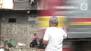 Penjaga perlintasan kereta api tanpa palang pintu, Wandi, berdiri tepat di samping perlintasan di Kawasan Petamburan, Jakarta, Jumat (4/6/2021). Di usianya yang tidak lagi muda, Pak Wandi tetap ada di mata pengendara dan pejalan kaki yang melintas di antara pemukiman warga. (merdeka.com/Imam Buhori)