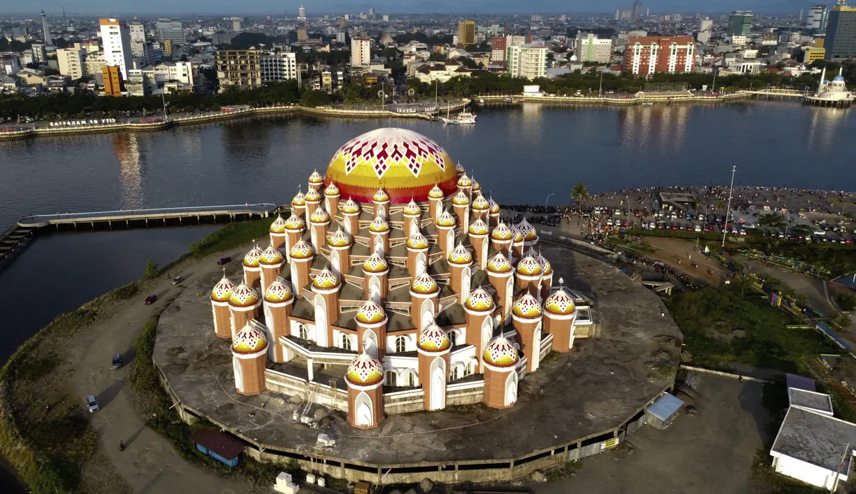Foto udara menunjukkan Masjid 99 Kubah selama bulan Ramadhan di Makassar (18/4/2021). Ruang sholat dapat menampung 3.880 jemaah, ruang mezzanine dapat menampung 1.005 jemaah, dan pelataran suci memuat 8.190 jemaah. Masjid ini dibangun di atas lahan reklamasi Pantai Losari. (AFP/Indra Abriyanto)