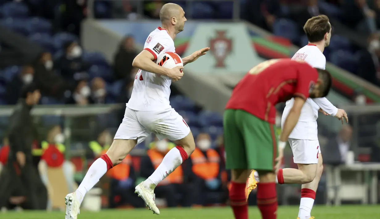 Penyerang Turki, Burak Yilmaz membawa bola usai mencetak gol ke gawang Portugal pada pertandingan playoff Piala Dunia 2022 di stadion Dragao di Porto, Portugal, Jumat (25/3/2022). Menang 3-1 membuat Timnas Portugal semakin dengan tiket Piala Dunia 2022. (AP Photo/Luis Vieira)