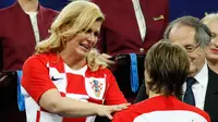 Presiden Kroasia, Kolinda Grabar-Kitarovic mengucapkan selamat kepada Kapten Kroasia, Luka Modric yang merebut penghargaan Pemain Terbaik saat penyerahan medali dan trofi Piala Dunia 2018 di Luzhniki Stadium, Minggu (15/7). (AFP/GANDAK ANDERSEN)