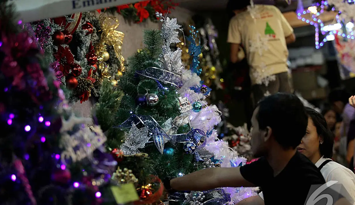 Sejumlah pengunjung memilih pohon Natal beserta hiasannya di Pasar Mangga Dua, Jakarta, Sabtu (13/12/2014). (Liputan6.com/Johan Tallo)
