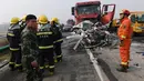 Petugas pemadam kebakaran dikerahkan ke lokasi kecelakaan beruntun 30 kendaraan di jalan raya dekat Yingshang, China timur, Rabu (15/11). Tak hanya mobil penumpang ukuran sedang saja yang terbakar hangus melainkan juga beberapa unit truk. (STR / AFP)