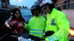 Kepolisian bekerjasama dengan Fullo mensosialisasikan larangan berhenti pada garis stop pada pengguna jalan diserta pembagian cokelat gratis pada pengendara yang tertib di kawasan Cideng, Jakarta, Senin (23/2). (Liputan6.com/Johan Tallo)