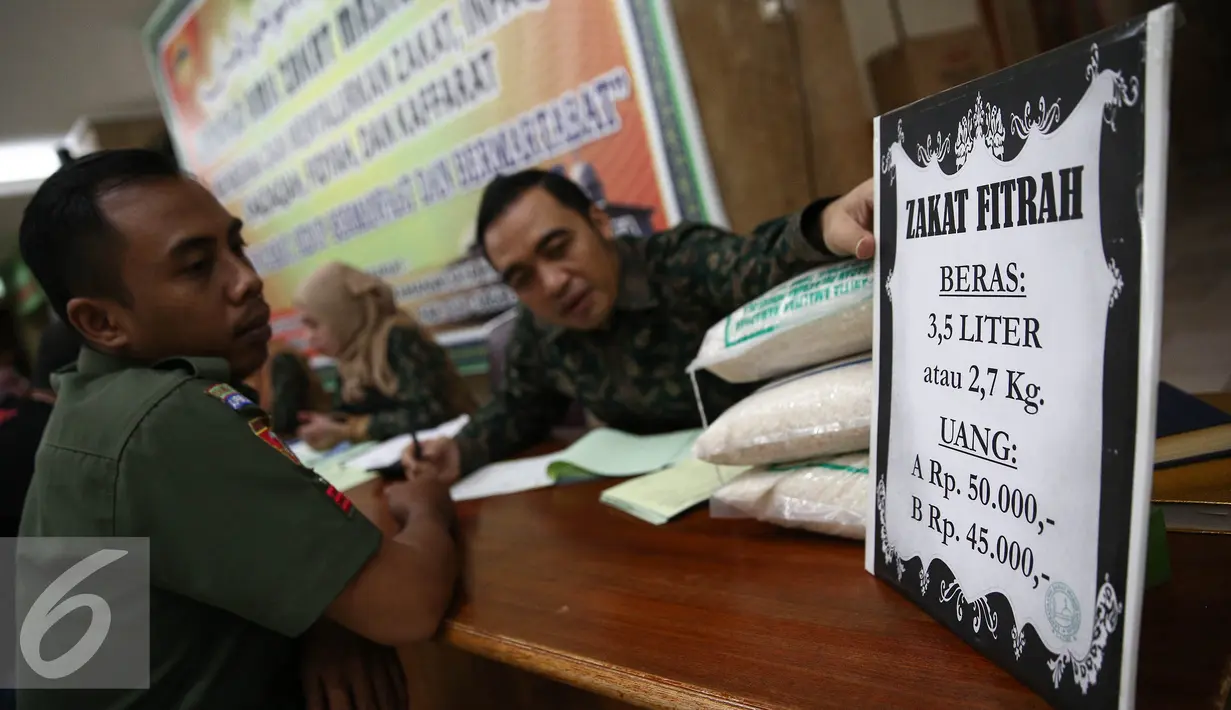 Petugas menunjukan harga zakat di Masjid Istiqlal, Jakarta, Jumat (1/7). Pembayaran zakat berupa beras 3,5 liter atau 2,7 kg atau uang senilai Rp 50 ribu untuk kelas A dan Rp 45 ribu untuk kelas B. (Liputan6.com/Faizal Fanani)