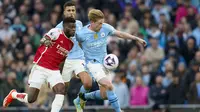Gelandang Manchester City, Kevin De Bruyne (kanan) menguasai bola dibayangi gelandang Arsenal, Thomas Partey pada laga pekan ke-30 Premier League 2023/2024 di Etihad Stadium, Manchester, Minggu (31/3/2024). (AP Photo/Dave Thompson)