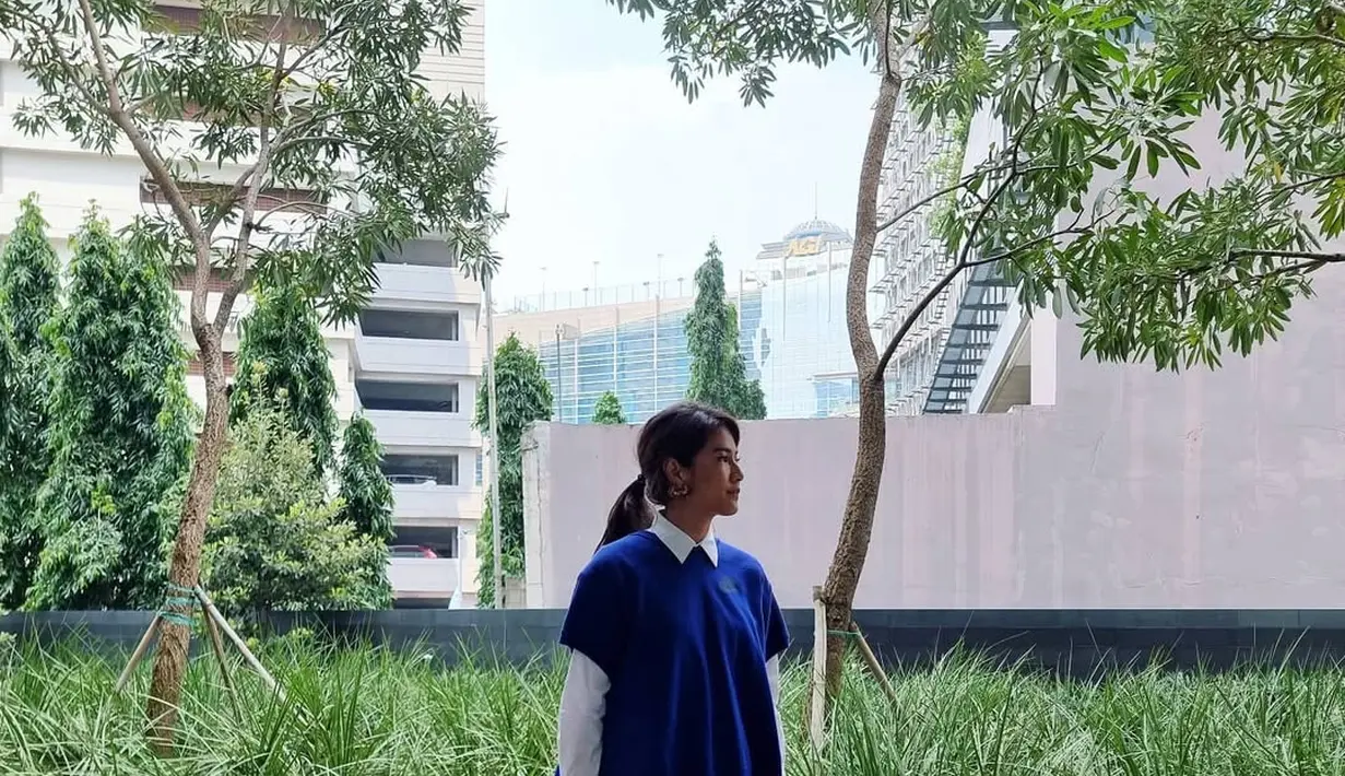 Di potret ini Dian Sastro kembali aplikasikan preppy look saat kenakan rok batik lilit. Namun kali ini dipadu dengan kemeja putih dan oversized wool outer biru [@therealdisastr]