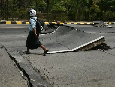 Seorang pria berjalan di sepanjang jalan yang rusak di Naypyidaw pada 28 Maret 2025. (Sai Aung MAIN/AFP)