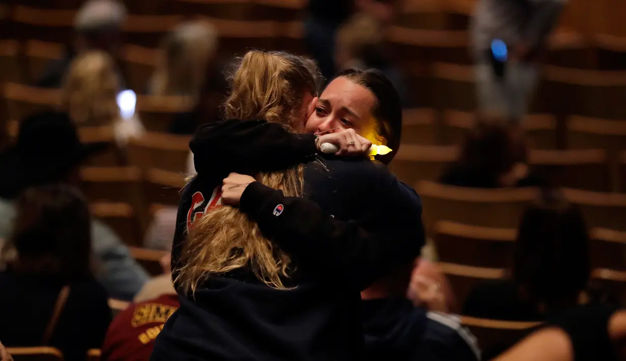Para pelayat berpelukan saat berkumpul untuk mengenang korban penembakan massal di bar California di Thousand Oaks, Amerika Serikat, Kamis (8/11). Sebagian besar korban meninggal adalah mahasiswa. (AP Photo/Marcio Jose Sanchez)