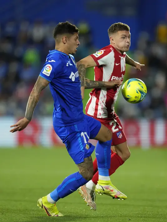 Bek Atletico Madrid, Kieran Trippier berebut bola dengan bek Getafe, Mathias Olivera pada laga pekan keenam Liga Spanyol di Stadion Coliseum Alfonso Perez, Rabu (22/9/2021) dini hari WIB. Luis Suarez memborong dua gol saat Atletico Madrid mengalahkan Getafe 2-1. (AP Photo/Manu Fernandez)