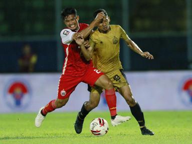 Pemain Persija Jakarta, Sandi Sute (kiri) berebut bola dengan pemain Bhayangkara Solo FC, TM Ichsan, pada laga Piala Menpora 2021 di Stadion Kanjuruhan, Malang, Rabu (31/3/2021). (Bola.com/M Iqbal Ichsan)