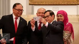 Seskab Pramono Anung  (kanan) berselfi dengan Kepala Staf Presiden Teten Masduki  (tengah) sebelum acara pelantikan dirinya yang dipimpin Presiden Jokowi di Istana Negara, Jakarta, Selasa (2/9). (Liputan6.com/Faizal Fanani)