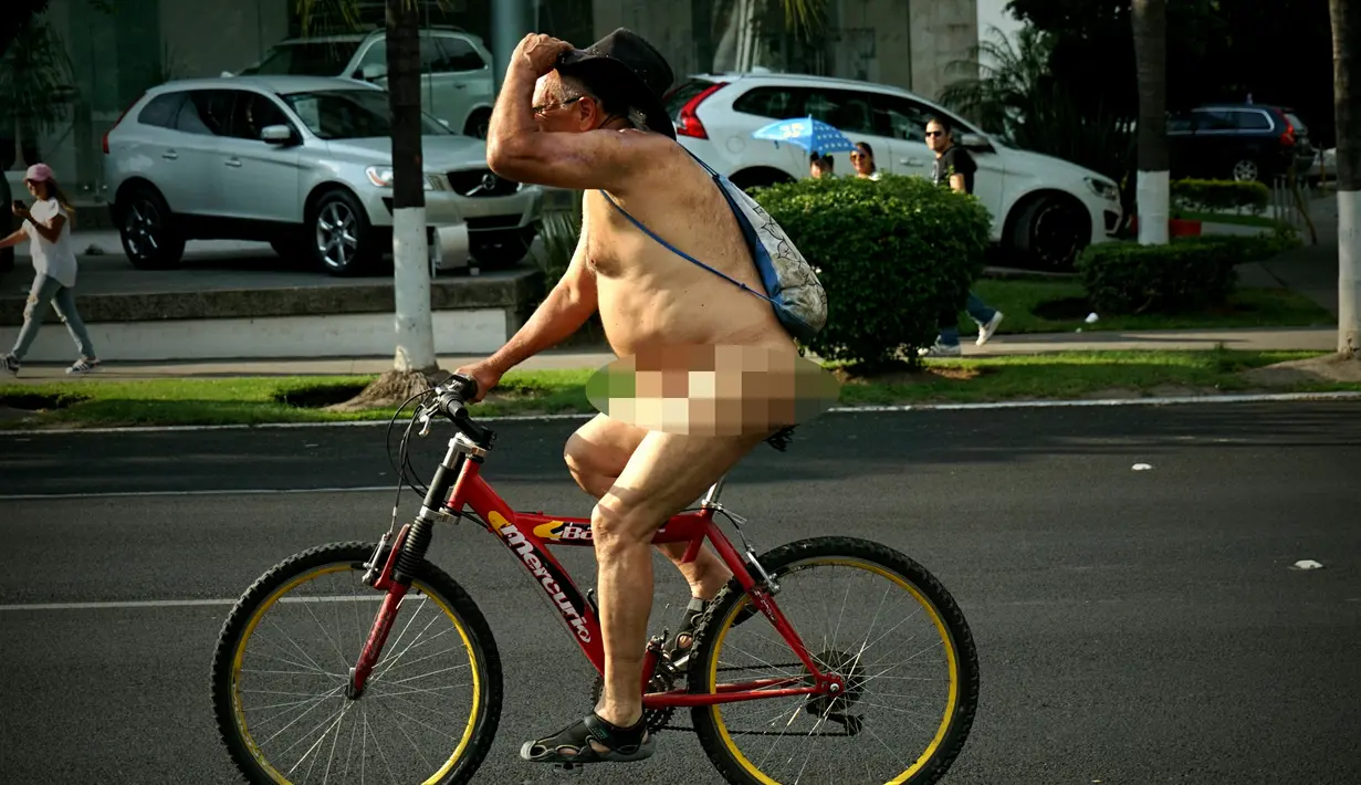 Seorang pria telanjang mengendarai sepeda saat mengikuti World Naked Bike Ride di Guadalajara, Jalisco, Meksiko (17/6). Acara ini digelar untuk memprotes polusi gas emisi dari mobil. (AFP Photo/Hector Guerrero)