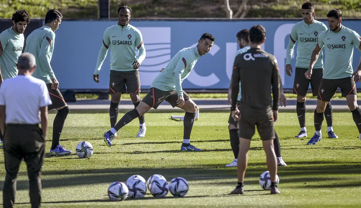 Penyerang Portugal, Cristiano Ronaldo (tengah) dan rekan satu timnya mengikuti sesi latihan di tempat latihan Cidade do Futebol di Oeiras (10/11/2021). Portugal akan bertanding melawan Irlandia pada Grup A kualifikasi Piala Dunia 2022  di Aviva Stadium. (AFP/Patricia De Melo Moreira)