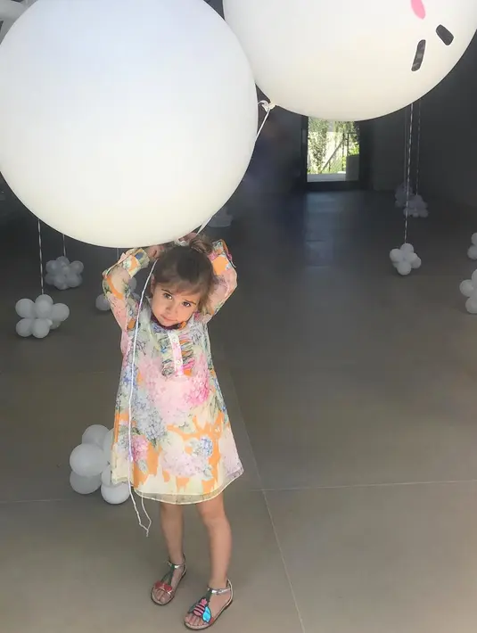 Gemasnya Penelope Disick saat berusaha memegang balon yang berukuran dua kali leih besar dari tubuhnya. (instagram/kourtneykardashian)